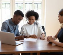African American Couple Signing Closing Documents with Realtor