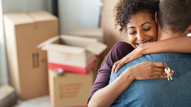 Person hugging partner with moving boxes in the background