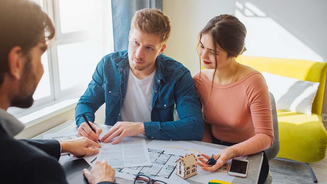 Young couple signing mortgage paperwork