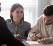 Couple signing papers to close on a house