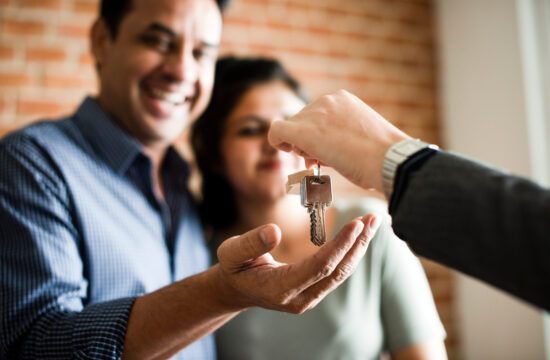 Couple being handed keys to their new home