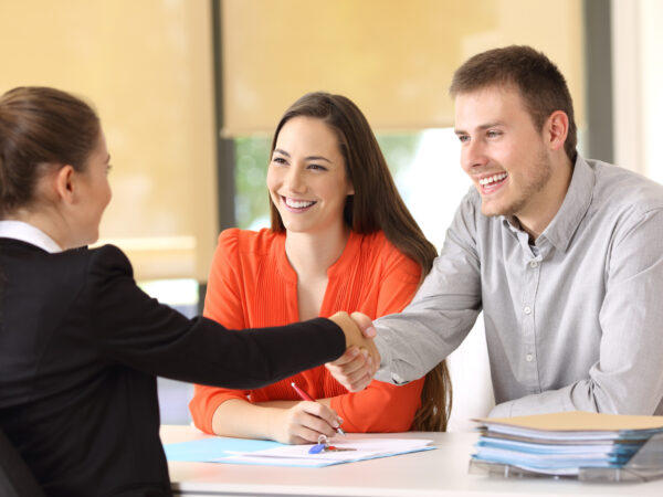 Young couple shaking hands with loan officer