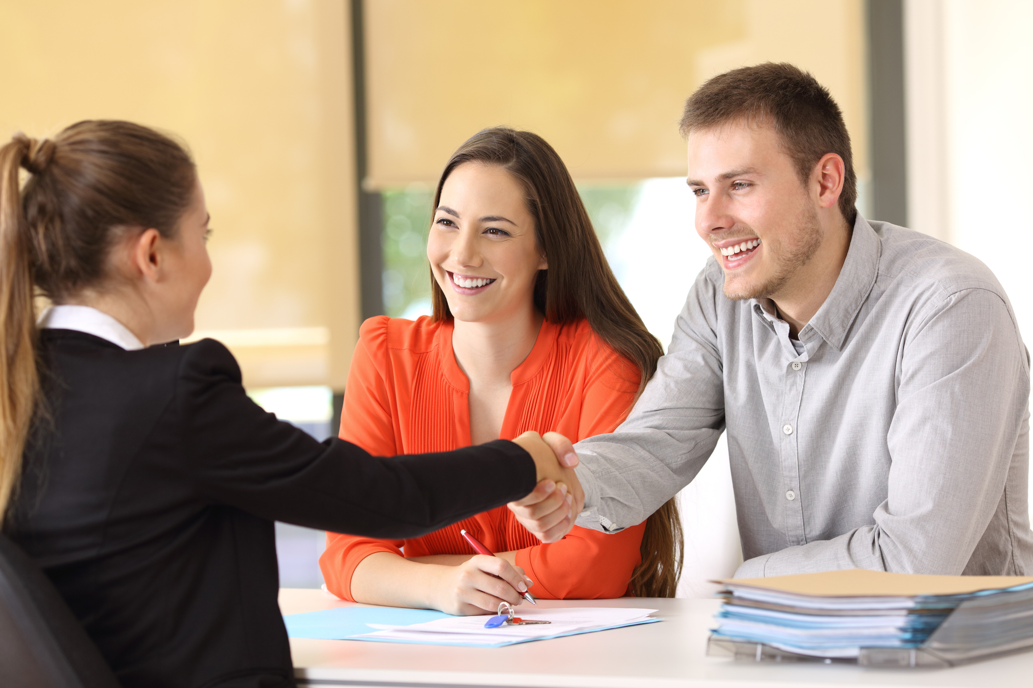 Young couple shaking hands with loan officer