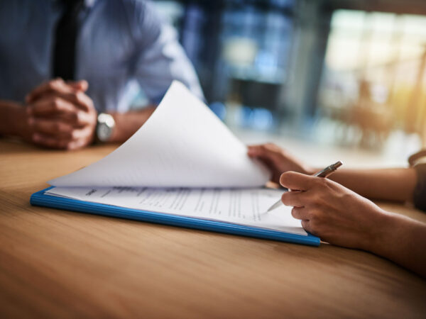 Close up shot of a man and woman completing paperwork together at a desk