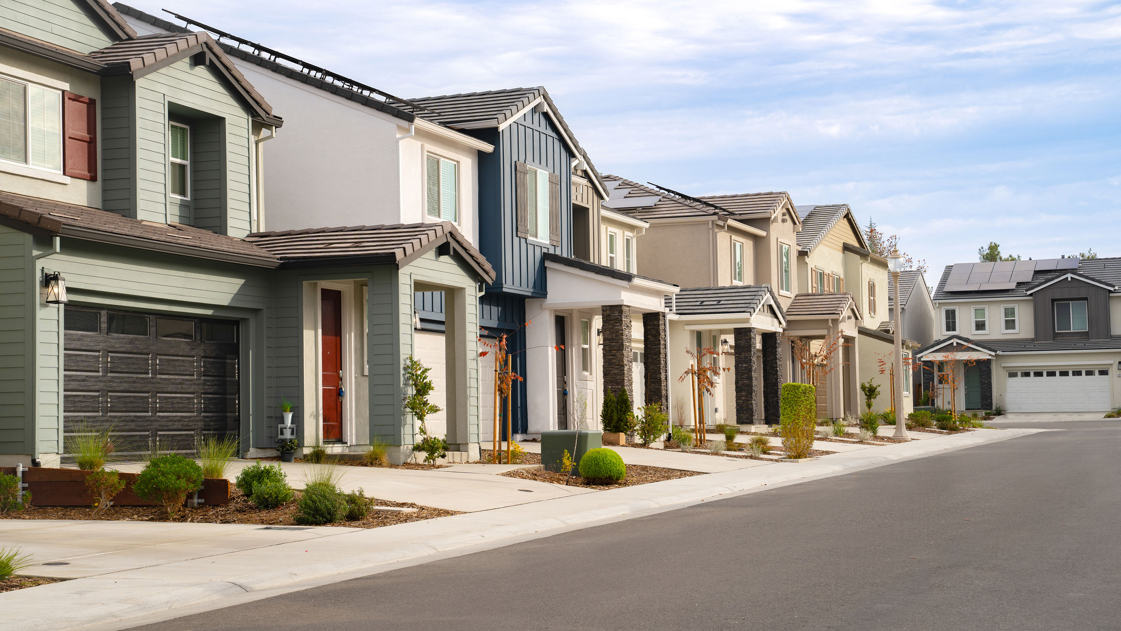 Street of two-story homes in a housing development.