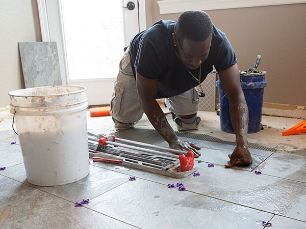 Person laying new tile in a home